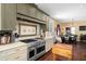 Modern kitchen features a stainless steel range and hood with seating area, alongside views into the sunlit dining area at 1603 S Arrawana Ave, Tampa, FL 33629