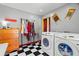 Modern laundry room with checkered floors, shelving, and front load washer and dryer at 1603 S Arrawana Ave, Tampa, FL 33629