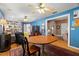 Bright living room with blue walls, ceiling fans, hardwood floors, and a vintage round dining table at 1603 S Arrawana Ave, Tampa, FL 33629