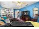 Cozy living room featuring custom shelving, a large television, and comfortable seating on hardwood floors at 1603 S Arrawana Ave, Tampa, FL 33629