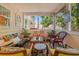 Relaxing screened-in porch with a variety of seating, wooden floors, and a view to the backyard at 1603 S Arrawana Ave, Tampa, FL 33629