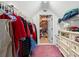 Organized walk-in closet with storage and doorway access to unfinished attic space at 1603 S Arrawana Ave, Tampa, FL 33629