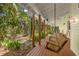 Relaxing back porch area with wooden floors and a swing offers peaceful views of surrounding nature at 187 Sage Cir, Crystal Beach, FL 34681