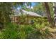 Charming home with a metal roof, a covered porch, and mature trees at 187 Sage Cir, Crystal Beach, FL 34681