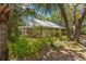Home exterior with metal roof, covered porch, lush landscaping, and inviting curb appeal at 187 Sage Cir, Crystal Beach, FL 34681