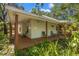 Charming home exterior with a spacious wraparound porch and lush, mature landscaping offers privacy at 187 Sage Cir, Crystal Beach, FL 34681