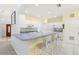 Bright eat-in kitchen features modern white cabinetry, an eat-at counter, and tile floors at 187 Sage Cir, Crystal Beach, FL 34681