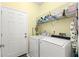 Well-equipped laundry room with washer, dryer, and ample shelving for storage and organization at 187 Sage Cir, Crystal Beach, FL 34681