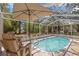 Relaxing screened pool area with sunshade umbrella and garden views at 187 Sage Cir, Crystal Beach, FL 34681