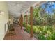 Spacious covered porch with rocking chairs, ceiling fans, and serene garden views at 187 Sage Cir, Crystal Beach, FL 34681