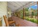 Relaxing screened porch offers outdoor seating, ceiling fan, and views of the lush landscaping, creating a perfect serene retreat at 187 Sage Cir, Crystal Beach, FL 34681