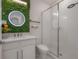 Modern bathroom features an accent wall with a vanity, vessel sink, lighted mirror, and glass-enclosed shower at 19554 Roseate Dr, Lutz, FL 33558
