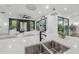 Modern kitchen with quartz countertops, stainless steel sink, and view to living room at 19554 Roseate Dr, Lutz, FL 33558