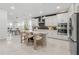 Contemporary kitchen features stainless steel appliances, white cabinets, island and open to dining area at 19554 Roseate Dr, Lutz, FL 33558