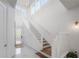 Elegant staircase with wooden steps and white railing, bathed in natural light at 19554 Roseate Dr, Lutz, FL 33558