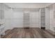 Spacious walk-in closet with custom white shelving and hanging racks for optimal storage solutions and hardwood flooring at 19554 Roseate Dr, Lutz, FL 33558
