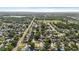 Wide aerial view of neighborhood with mature trees near a body of water with clear blue sky at 1985 Hastings Dr, Clearwater, FL 33763