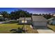 Charming single-story home with a well-maintained lawn and attached two-car garage at dusk at 1985 Hastings Dr, Clearwater, FL 33763
