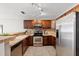 Well-lit kitchen with stainless steel appliances, wood cabinets, and neutral countertops at 1985 Hastings Dr, Clearwater, FL 33763