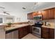 Well-lit kitchen with stainless steel appliances, wood cabinets, and neutral countertops at 1985 Hastings Dr, Clearwater, FL 33763
