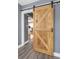 Close up of interior barn door with black hardware and wood flooring at 2016 Douglas Ave, Clearwater, FL 33755