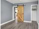 Bedroom features include gray-painted walls, wood-look flooring, and a sliding barn door at 2016 Douglas Ave, Clearwater, FL 33755