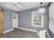 Bedroom featuring plank floors, a ceiling fan, a side sliding barn door, and closet for storage at 2016 Douglas Ave, Clearwater, FL 33755