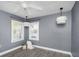 Cozy bedroom with grey walls, two bright windows, ceiling fan, and plank flooring at 2016 Douglas Ave, Clearwater, FL 33755