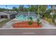 Charming turquoise bungalow features a manicured lawn and a beautifully graveled yard at 2016 Douglas Ave, Clearwater, FL 33755