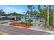 Charming turquoise bungalow features a manicured lawn and a long driveway at 2016 Douglas Ave, Clearwater, FL 33755