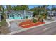 Charming turquoise bungalow features a manicured lawn and a beautifully graveled yard at 2016 Douglas Ave, Clearwater, FL 33755