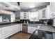 Updated kitchen with white cabinets, stainless steel dishwasher and sink with a modern countertop design at 2016 Douglas Ave, Clearwater, FL 33755