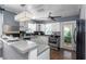 Well-lit kitchen featuring white cabinets, stainless steel appliances, and a modern countertop with hardwood floors at 2016 Douglas Ave, Clearwater, FL 33755