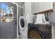 The laundry room includes a stackable washer and dryer with overhead cabinet storage and tile flooring at 2016 Douglas Ave, Clearwater, FL 33755