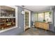 Cozy enclosed patio with gray siding, tile floors, large windows and a stylish wooden console table at 2016 Douglas Ave, Clearwater, FL 33755