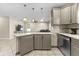 Kitchen peninsula with gray cabinetry, granite counters, and open to the living area at 212 28Th S St, St Petersburg, FL 33712
