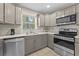 Updated kitchen boasting stainless steel appliances, grey cabinets, and tile flooring at 212 28Th S St, St Petersburg, FL 33712