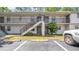 Apartment complex with exterior staircase, black railings, and parking spots at 2122 Bradford St # 505, Clearwater, FL 33760