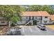 Two-story apartment complex features exterior stairs and parking with mature tree providing shade at 2122 Bradford St # 505, Clearwater, FL 33760
