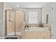 This bathroom includes a relaxing soaking tub, glass shower, and a bright window at 21383 Southern Charm Dr, Land O Lakes, FL 34637