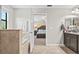 The bright bathroom features a soaking tub, vanity, and an open view of the main bedroom at 21383 Southern Charm Dr, Land O Lakes, FL 34637