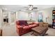Upstairs bonus room featuring a comfortable red couch, storage, and great natural lighting at 21383 Southern Charm Dr, Land O Lakes, FL 34637