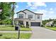Inviting two-story home with lush landscaping, a covered front porch, and a convenient mailbox at 21383 Southern Charm Dr, Land O Lakes, FL 34637