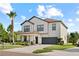Elegant two-story home showcasing a manicured lawn, a stately palm tree, and an attached garage at 21383 Southern Charm Dr, Land O Lakes, FL 34637