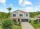 Beautiful two-story home with a well-manicured lawn, mature landscaping, and attached two-car garage at 21383 Southern Charm Dr, Land O Lakes, FL 34637