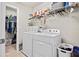 Well-equipped laundry room with a washer, dryer, shelving, and convenient walk-in closet at 21383 Southern Charm Dr, Land O Lakes, FL 34637