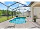 Sparkling screened-in pool with a paved deck and lush greenery at 21383 Southern Charm Dr, Land O Lakes, FL 34637