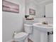 Bright bathroom featuring a pedestal sink, toilet, neutral decor, and decorative accents at 226 5Th N Ave # 605, St Petersburg, FL 33701
