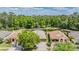 Aerial view of the neighborhood showcasing the home, pond, and surrounding wooded areas at 25324 Lexington Oaks Blvd, Wesley Chapel, FL 33544