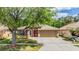 Charming single story home with a brick pathway, manicured lawn, and inviting red door at 25324 Lexington Oaks Blvd, Wesley Chapel, FL 33544